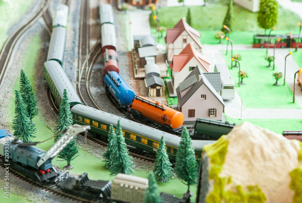 A breadboard model of a railway with a locomotive, wagons, trees, buildings, lawns. View from above. A breadboard model of a railway with a locomotive, wagons, trees, buildings, lawns. View from above.