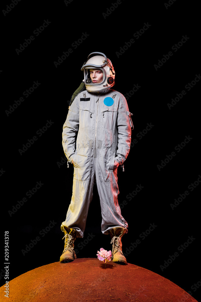 astronaut in spacesuit and helmet standing on peony on planet astronaut in spacesuit and helmet standing on peony on planet