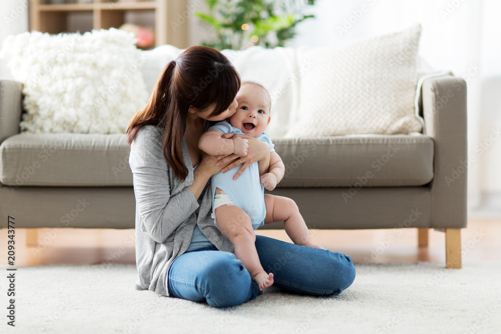 family and motherhood concept - happy smiling young asian mother with little baby at home family and motherhood concept - happy smiling young asian mother with little baby at home