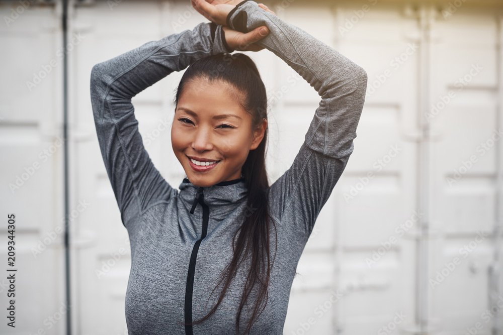 Young Asian woman in sportswear smiling before a jog Young Asian woman in sportswear smiling before a jog