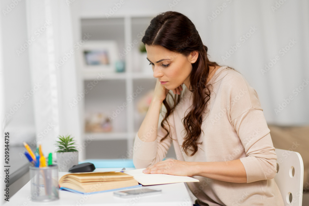 education and people concept - tired female student with book learning at home education and people concept - tired female student with book learning at home