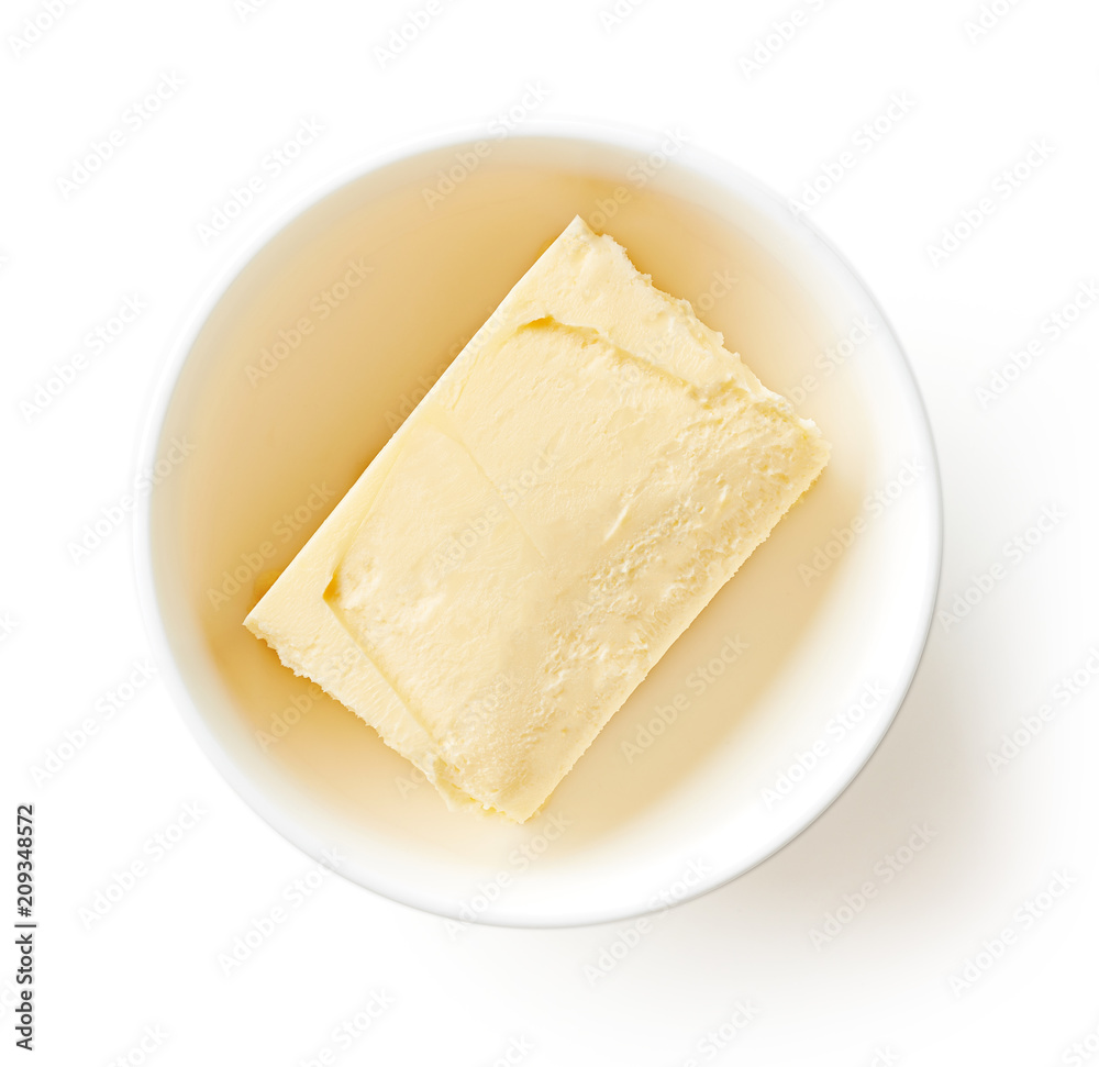 Butter in bowl isolated on white, from above