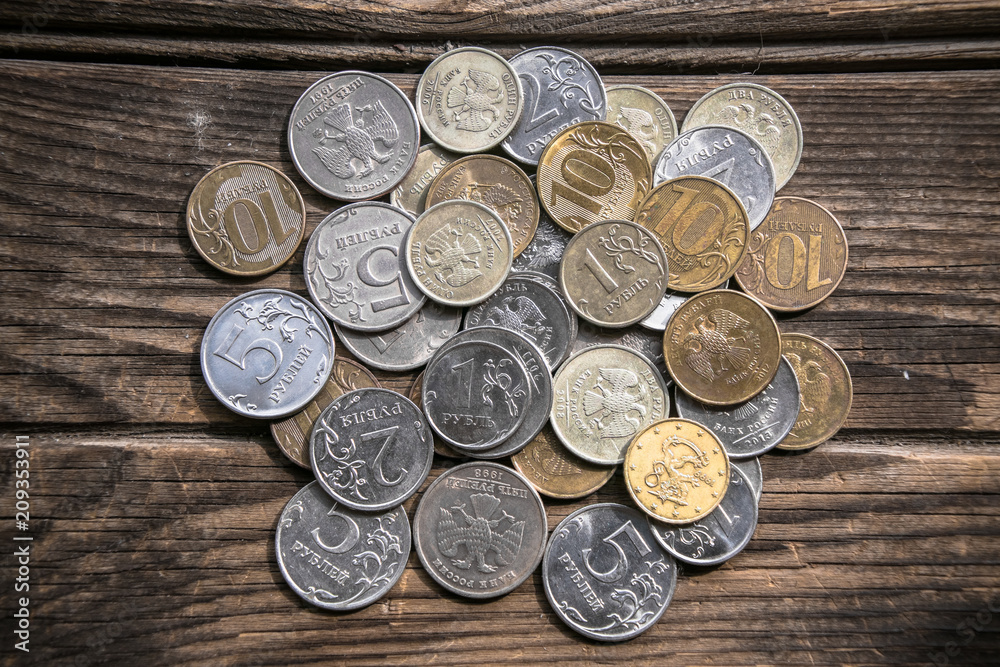 Bunch of coins on the aged wooden surface. Russian roubles. Miserable poverty. Rural dreams of wealth. The concept of social inequality. Bunch of coins on the aged wooden surface. Russian roubles. Miserable poverty. Rural dreams of wealth. The concept of social inequality.