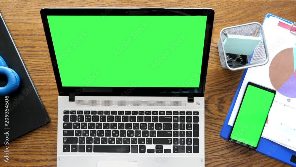 Laptop and smartphone with green screen on table. Dolly footage Laptop and smartphone with green screen on table. Dolly footage