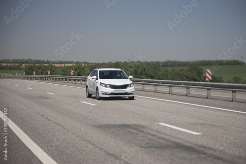 Obraz na płótnie White hatchback rides on the highway