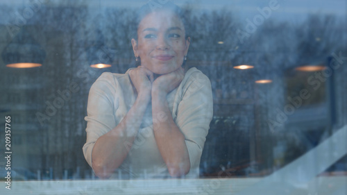 Young woman waiting in cafe for her order to be brought by the waiter