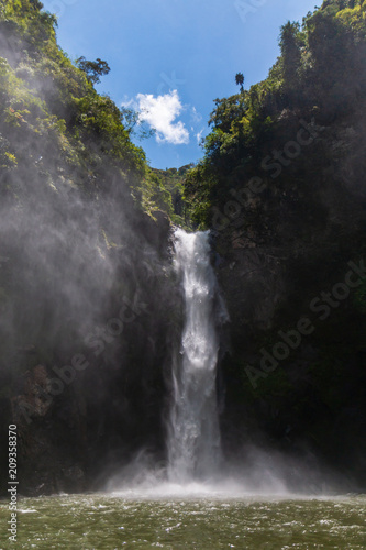 A 60m waterfall in a deep valley surrounded by rainforest (Tappiya Falls) photo