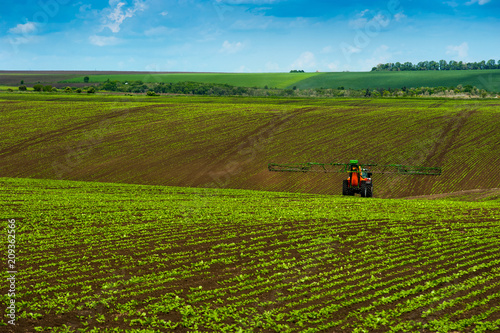 agricultural hills landscape with tractor spraying