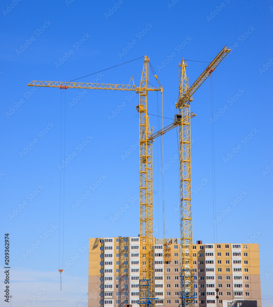 construction cranes against the blue sky