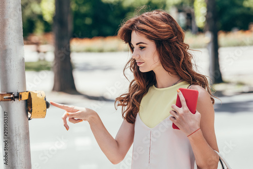 Εκτύπωση καμβά side view of young woman pressing button on pedestrian crossing