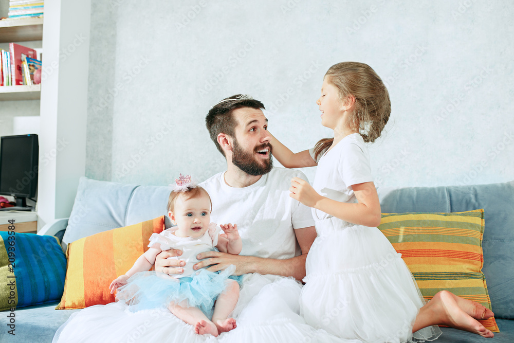 The happy father and his baby daughters at home The happy father and his baby daughters at home