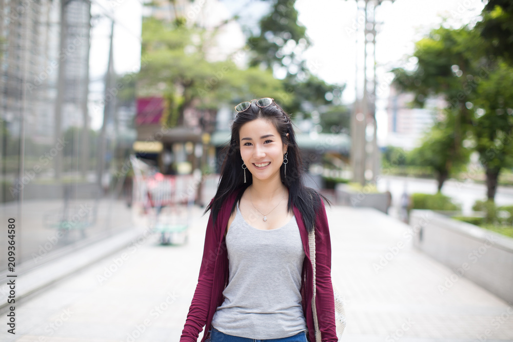 lifestyle fashion portrait of young stylish hipster Asia woman walking on the street, wearing cute trendy outfit