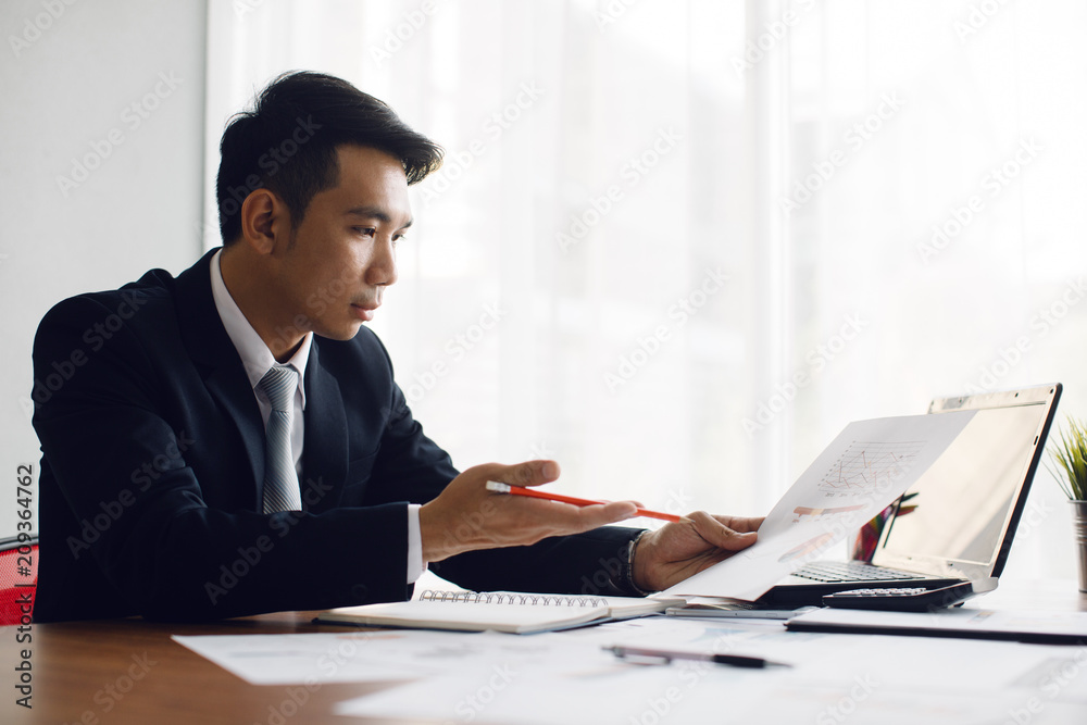 Business man working at office with laptop and documents on his desk Business man working at office with laptop and documents on his desk