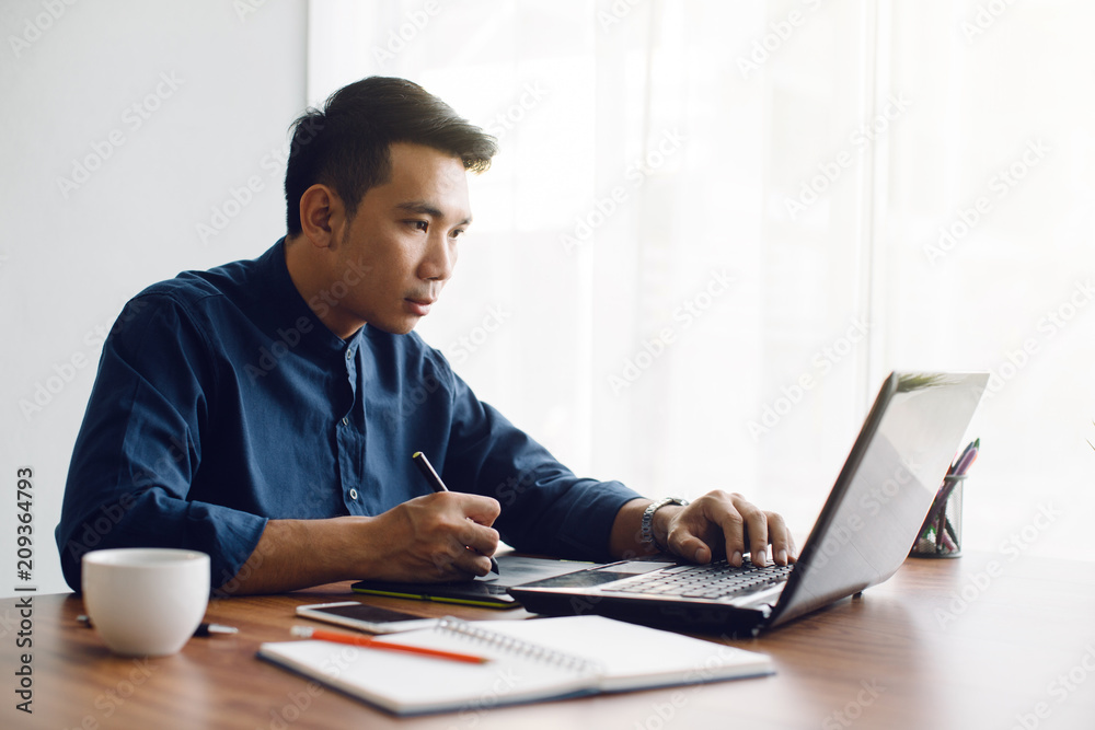 graphic designer working with laptop.creative man using pen and digital tablet at modern office. graphic designer working with laptop.creative man using pen and digital tablet at modern office.