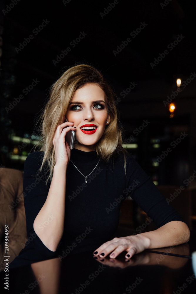 Young woman talking on the phone with on table in cafe. Young woman talking on the phone with on table in cafe.