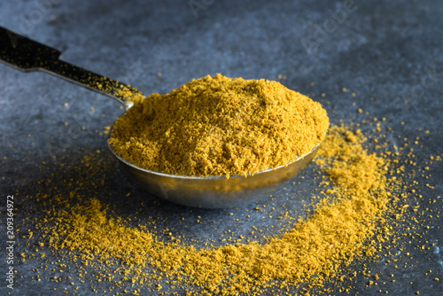 Fototapeta Naklejka Na Ścianę i Meble -  Curry Powder Spilled from a Teaspoon