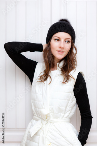 Hipster Style Brunette Girl Swag wearing Black fashion beanie knitted hat with bumbon pumpon. Season Fall Winter