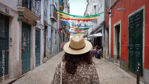Young travel woman is walking on the beautiful decorated street of Lisbon in Portugal         