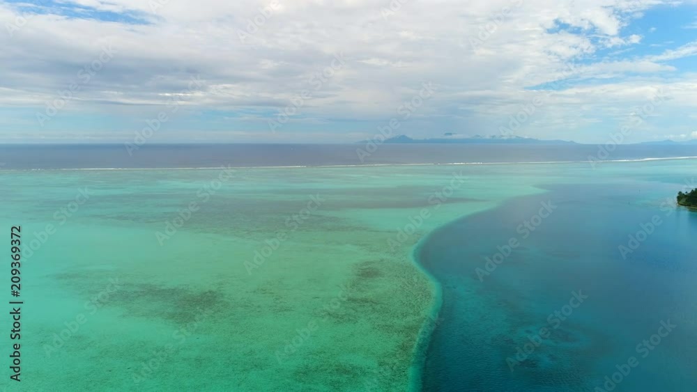 Aerial panoramic view of coral barrier reef around Huahine island, turquoise crystal clear water of blue lagoon, Raiatea and Tahaa on horizon - South Pacific Ocean, seascape of French Polynesia, 4k Aerial panoramic view of coral barrier reef around Huahine island, turquoise crystal clear water of blue lagoon, Raiatea and Tahaa on horizon - South Pacific Ocean, seascape of French Polynesia, 4k