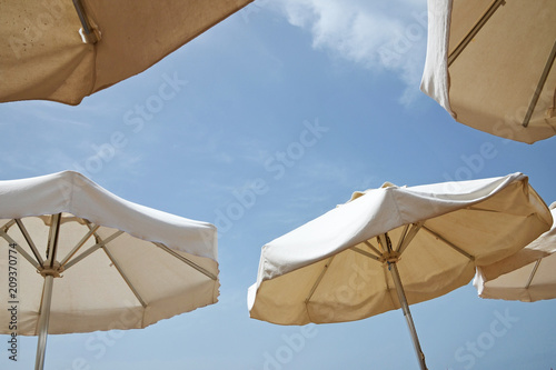 White beach umbrellas.The blue sky.The concept of a beach holiday