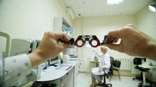 Optical eyeglass frames close-up, ophthalmologist examining patient with optometrist trial frame, visual inspection device in ophthalmological clinic, photo