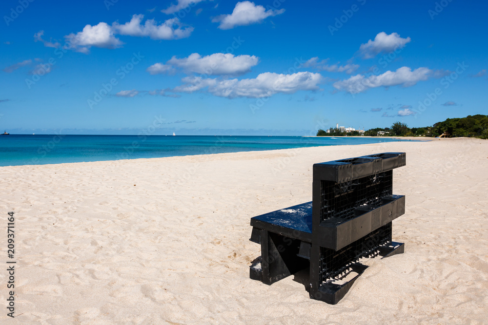 Black bench on a beach in Barbados. Idyllic afternoon at the beach in ...