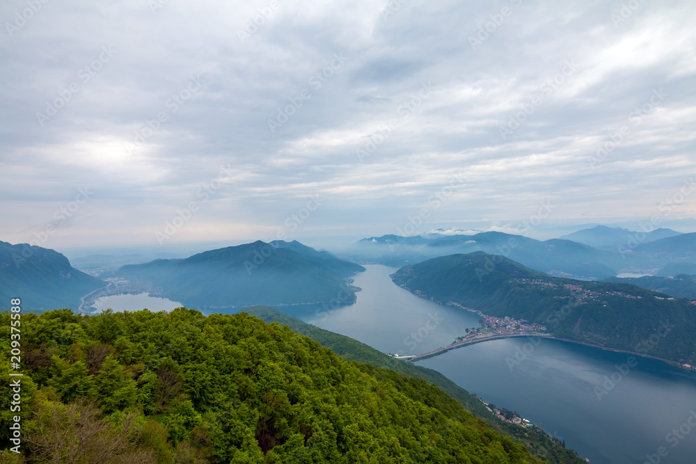 Balcony of Italy - Panorama of Lake Lugano in cloudy day. Alps with Mount blanc in background. Lombardia, Italy