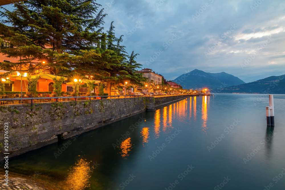 Fototapeta premium holidays in Italy - a view of a city Bellano, with the most beautiful lake in Italy - Lago di Como in background. Area of famous Belano City at sunset