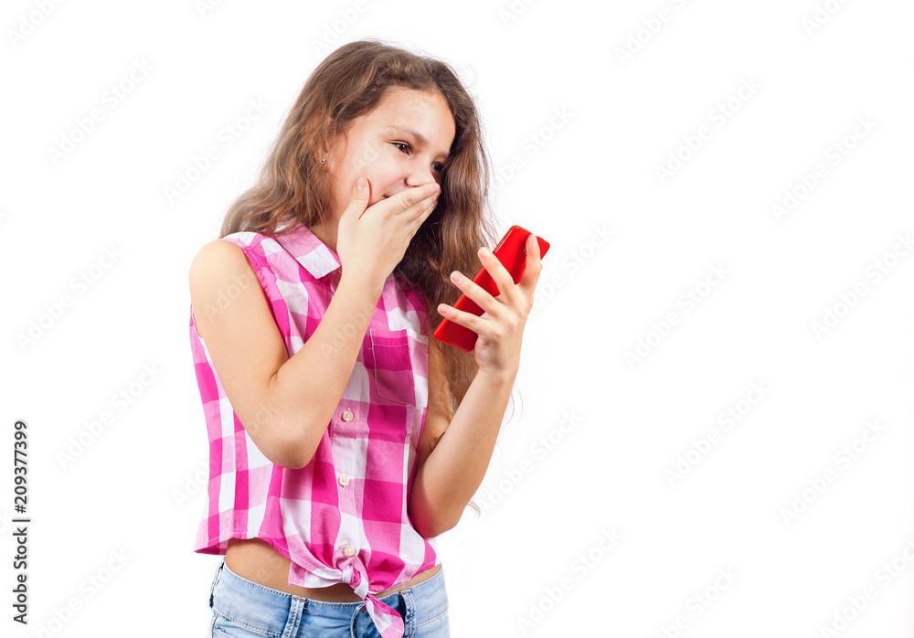 Cute little girl looks in smartphone and covers her mouth in surprise Cute little girl looks in smartphone and covers her mouth in surprise