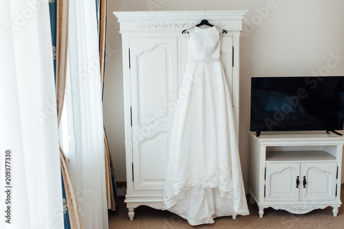 Wedding dress hanging on the cupboard