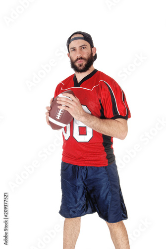 Young football player standing with his football in his hand