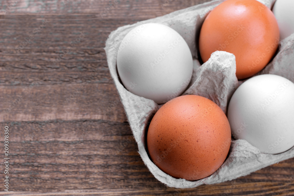 Brown chicken eggs in a tray for eggs on a brown wooden background Brown chicken eggs in a tray for eggs on a brown wooden background