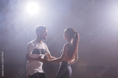 Active happy adults dancing bachata together in dance class