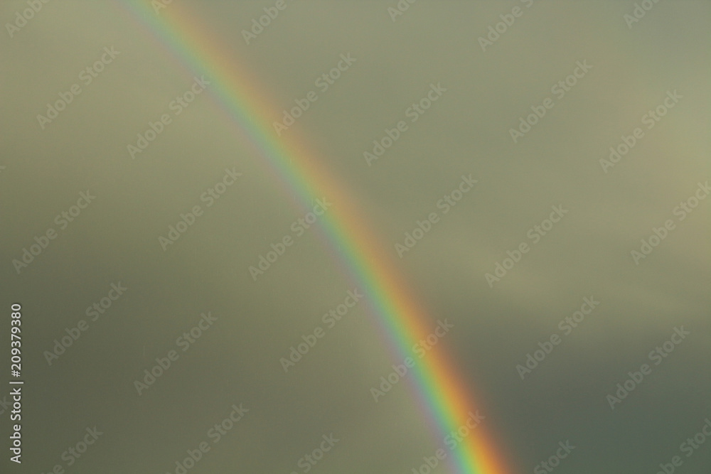 A beautiful bright rainbow and dark rain clouds. Close-up. Background. landscape. A beautiful bright rainbow and dark rain clouds. Close-up. Background. landscape.