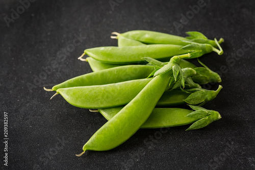 Freshly picked snow peas on a black background.