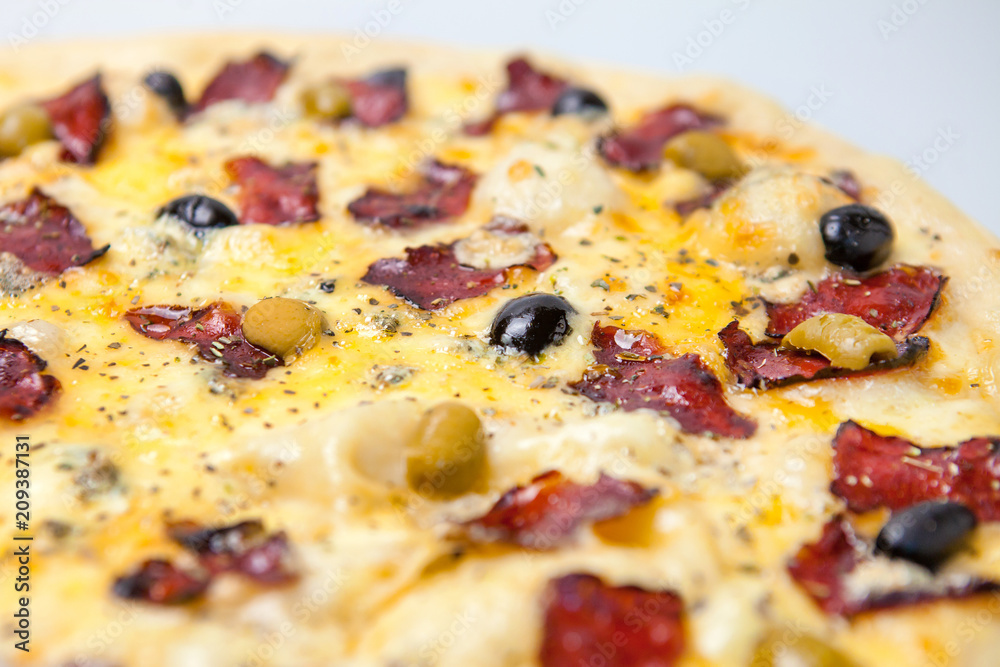 aromatic pizza with bacon, seasonings, cheese and vegetables is on the table in the pizzeria aromatic pizza with bacon, seasonings, cheese and vegetables is on the table in the pizzeria