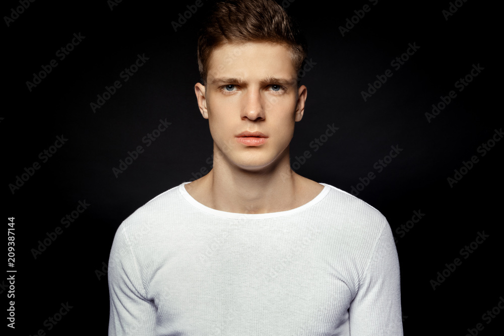 Fototapeta premium Male in white sport suit on black background