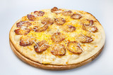 ready pizza with pieces of sausage, cheese and seasonings is on a wooden board on the table