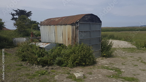 Run down old rusty corrugated tin shed surrounded by weeds in a field Appledore North Devon United Kingdom