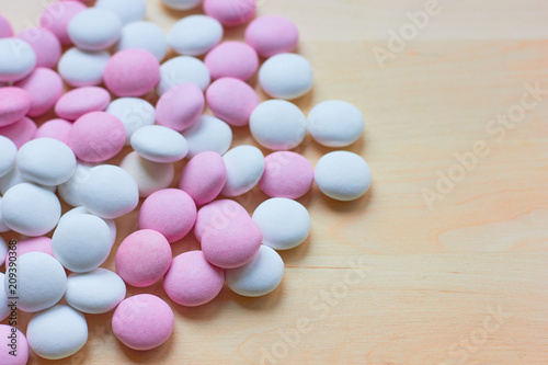 White and pink round candies are scattered on the table.