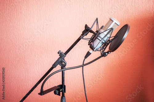 Microphone on a stand with an orange wall in the background