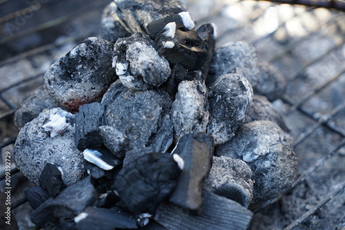 Glowing coals to hotdog grill with a charcoal barbecue in the garden 