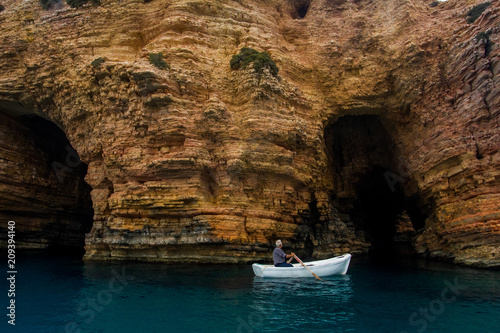 Small fish boat entering a cave photo