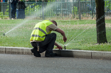 Leinwandbilder Olivgrün transportation company employee adjusting automatic sprinklers on tramway line  © pixarno
