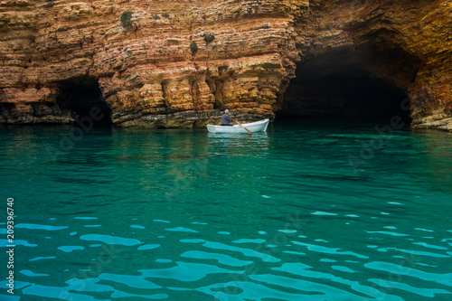 Small fish boat entering a sea cave
