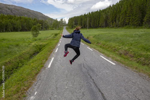 Happy girl  Jumping on the road in Hongset Northern Norway