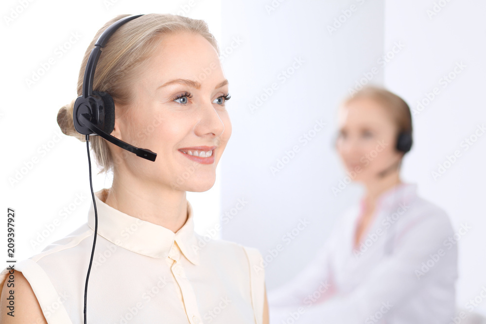 Bright call center office. Two blonde women in a headset Bright call center office. Two blonde women in a headset