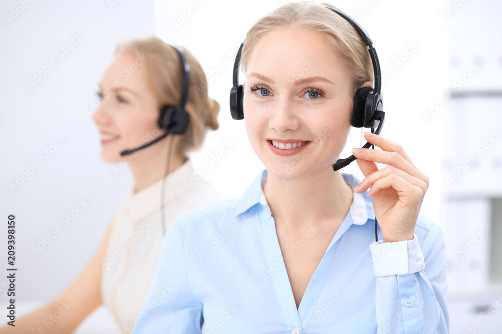 Bright call center office. Two blonde women in a headset Bright call center office. Two blonde women in a headset