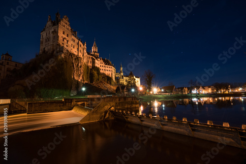 Das Hohenzollernschloss in Sigmaringen liegt direkt an der Donau, der Vollmond  neben dem Schloss beleuchtet die Umgebung. photo