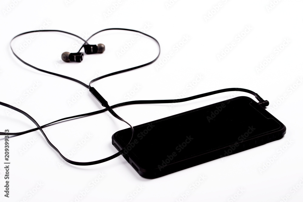 Obraz premium Black phone with headphones in the shape of a heart.
